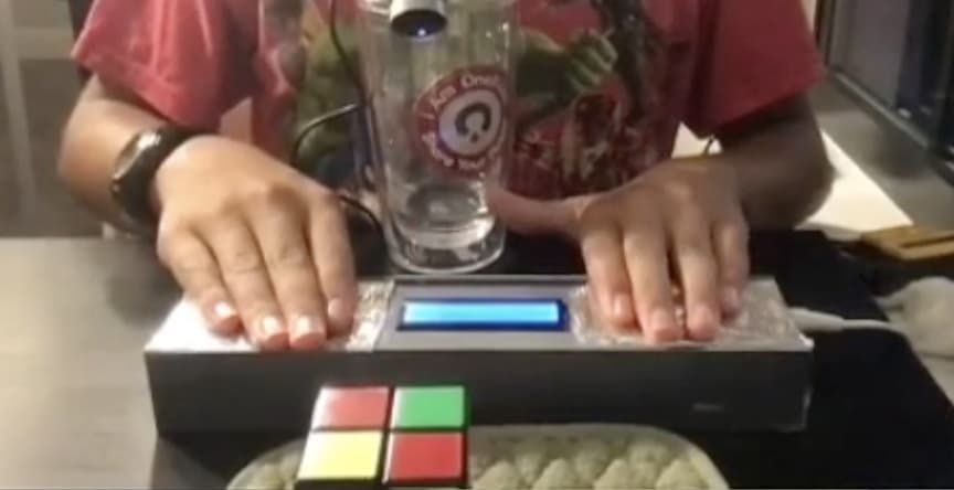 Hands on the capacitive pads of the second timer during a solve